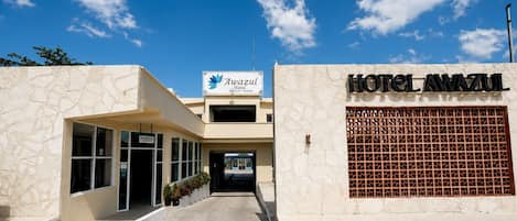 L’entrée d’un hôtel, avec un comptoir de réception et une enseigne indiquant « Hôtel Awasul ».