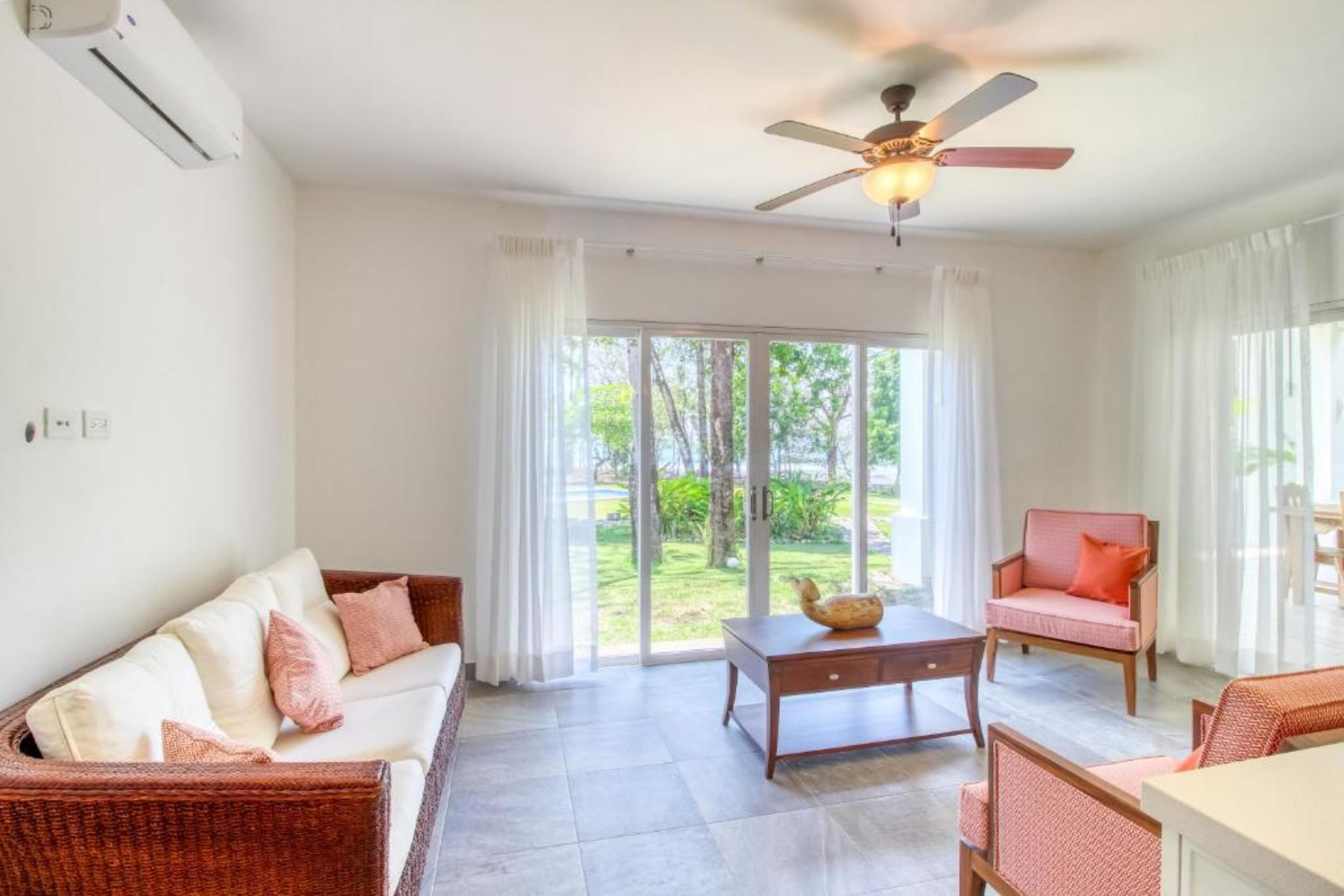 A spacious living room with a ceiling fan, a sofa, a chair, and a table.