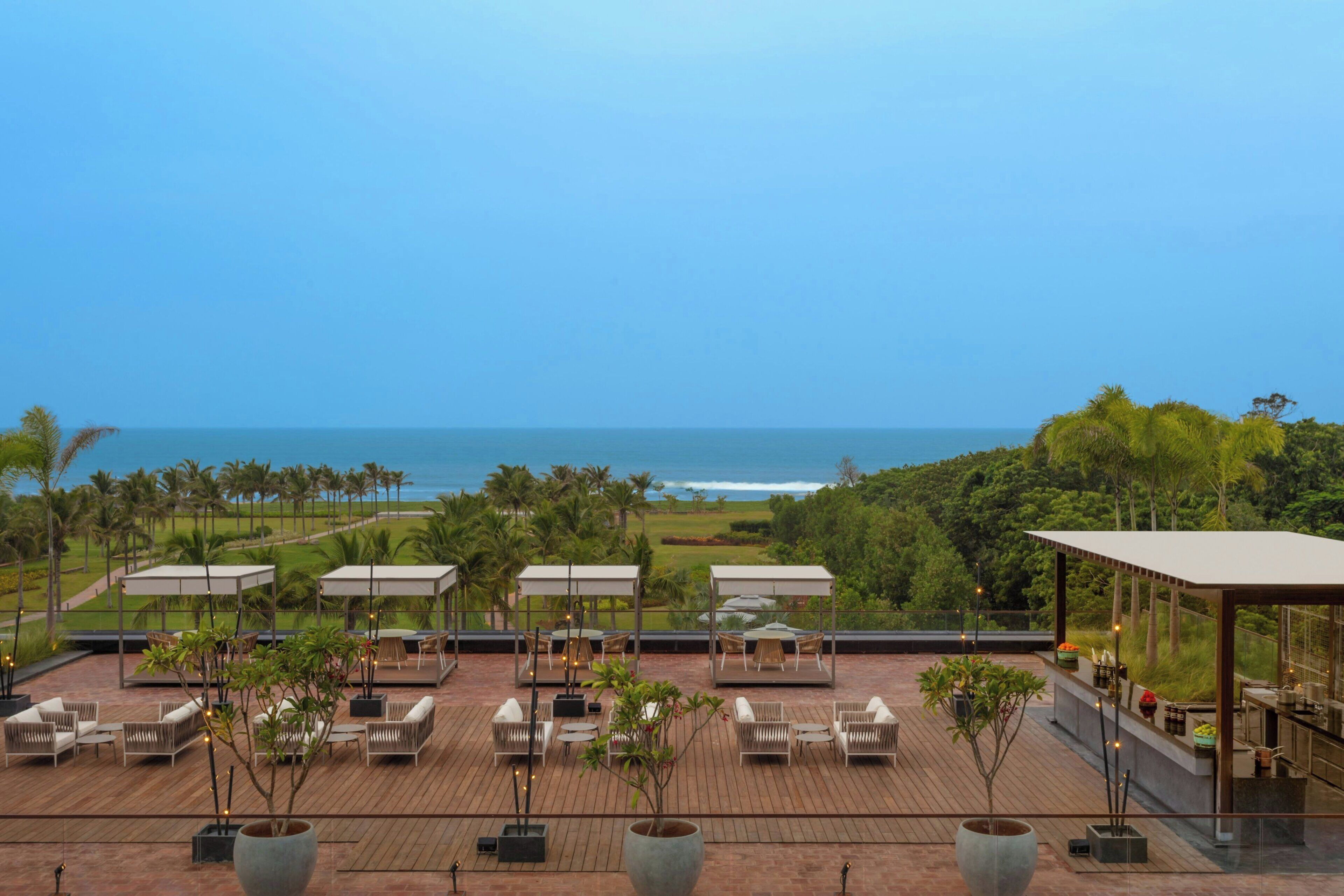 A rooftop terrace with outdoor seating and a view of the ocean.