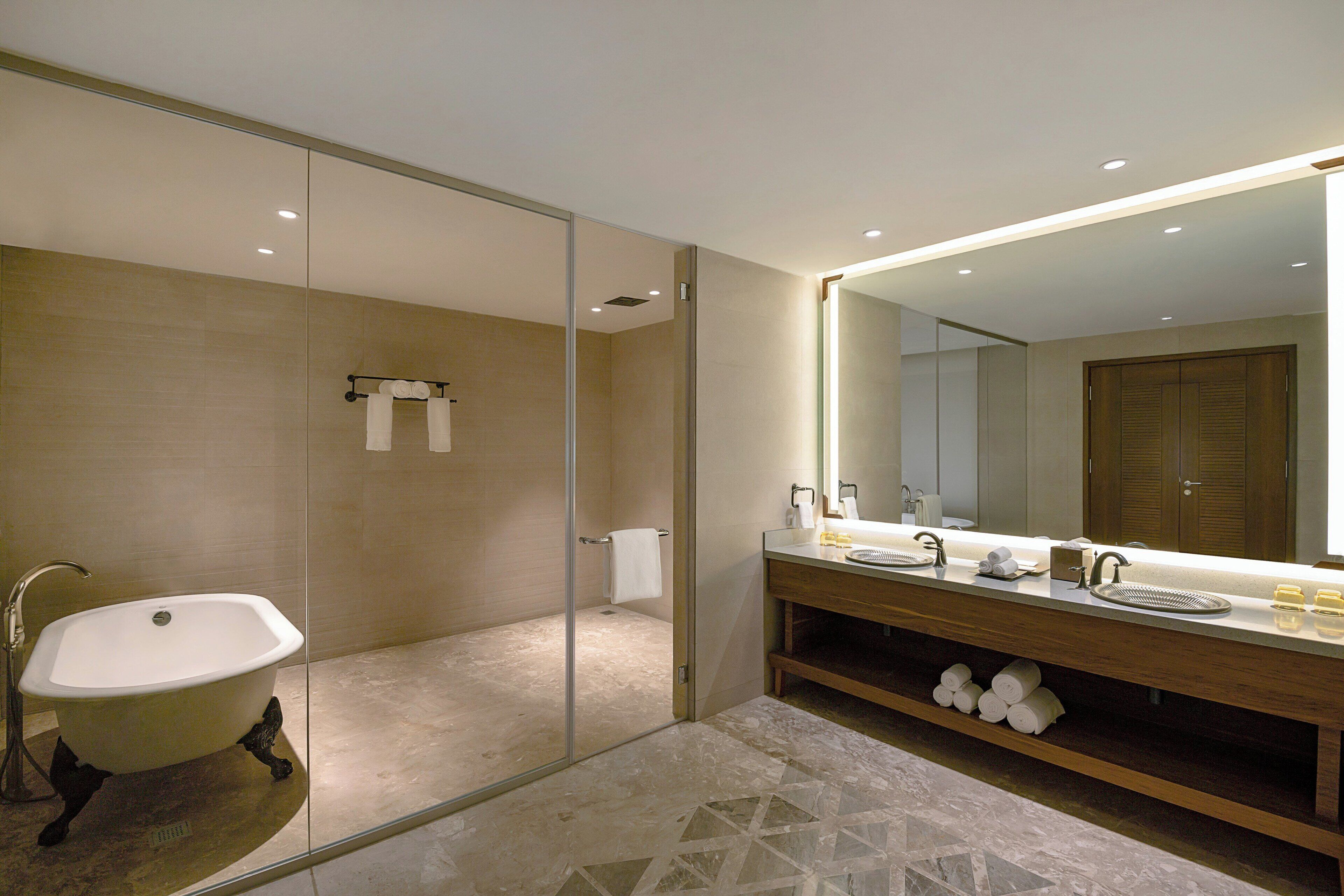 A modern bathroom with a freestanding bathtub, a large mirror, and a vanity with a sink and countertop.