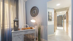 A modern room with a desk, lamp, decorative clock, and a tall vase. - San Peter Angels Two (Rome)