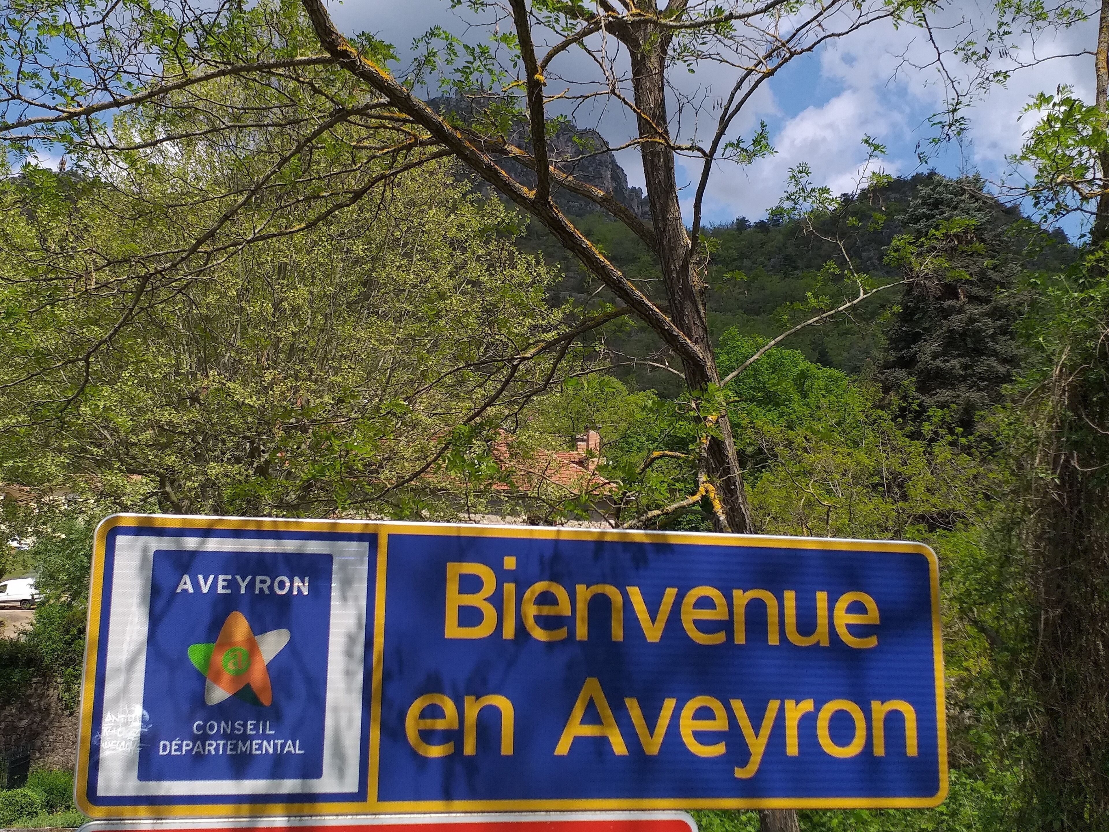 Un cartel de bienvenida a Aveyron, con un logotipo y texto.