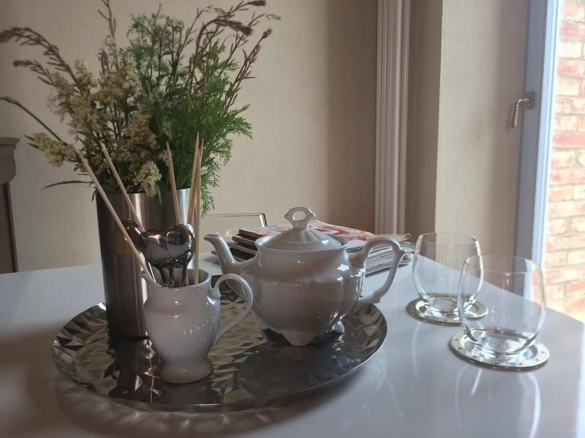Ein Esstisch mit Teekanne, Tassen und einer Serviertschale.