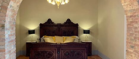 Une chambre à coucher avec un grand lit en bois, deux lampes de chevet et un lustre.