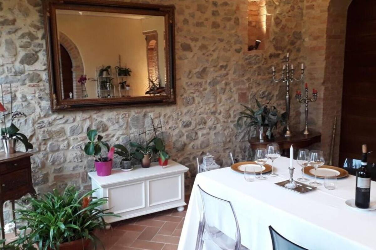 A dining area with a stone wall, a white buffet, and a table set for a meal.