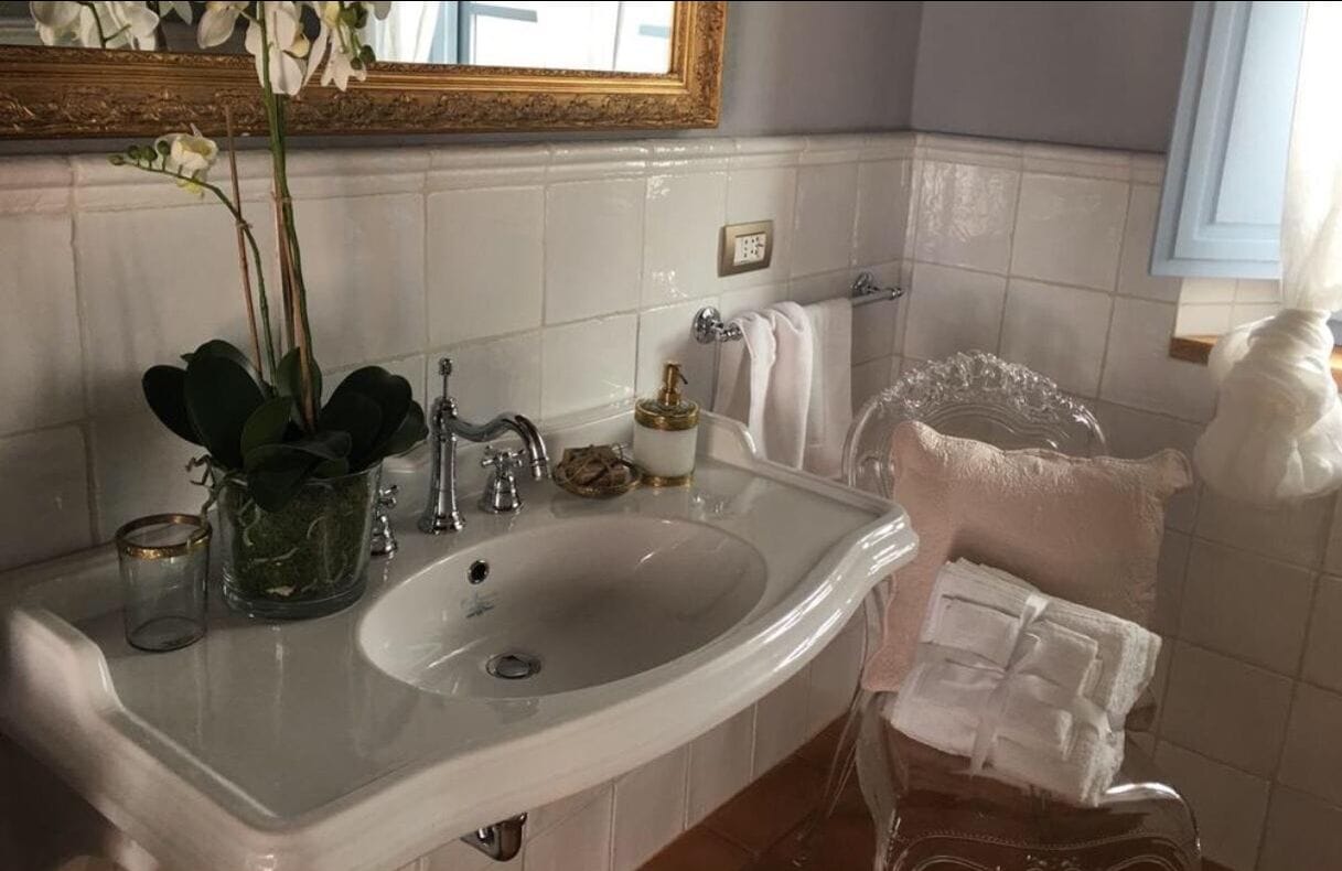 Une salle de bain avec un lavabo blanc, un miroir et un porte-serviettes.