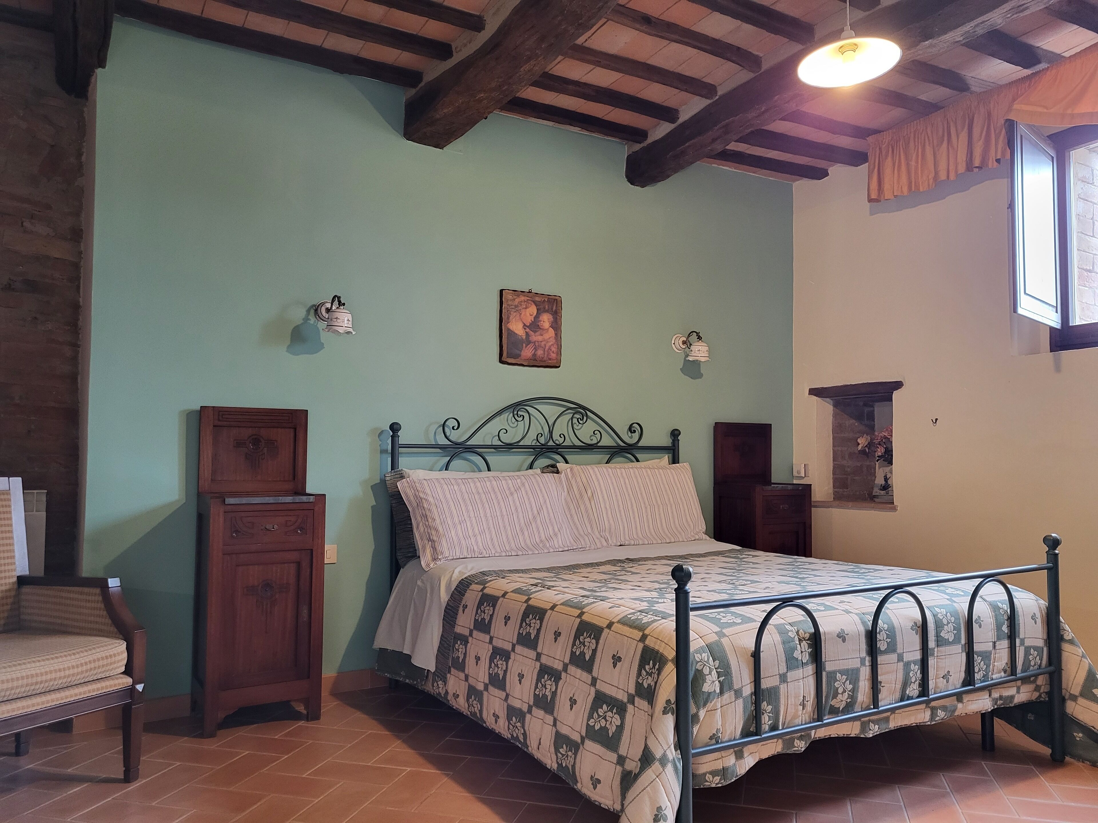 Une chambre à coucher avec un lit, des meubles en bois et une fenêtre.