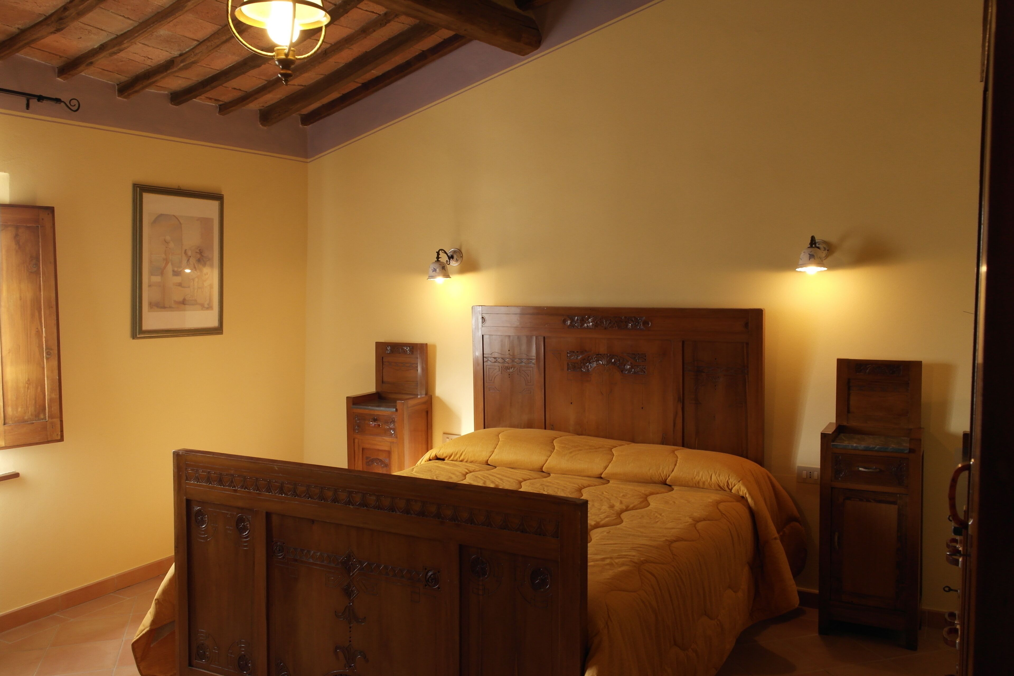 A bedroom with a wooden bed, wooden nightstands, and a wooden wardrobe.