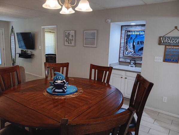 A dining area with a round wooden table, six chairs, and a decorative centerpiece.