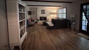 Ein Wohnzimmer mit Kamin, einer Couch, einem Couchtisch und einem Bücherregal.