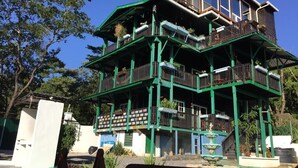 Un immeuble à plusieurs étages doté de balcons, avec une fontaine et une piscine au premier plan.