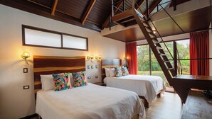 Habitación de hotel con dos camas, cabecero de madera, un escritorio y una escalera.