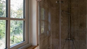 Ein Badezimmer mit Badewanne, Dusche und Fenster.