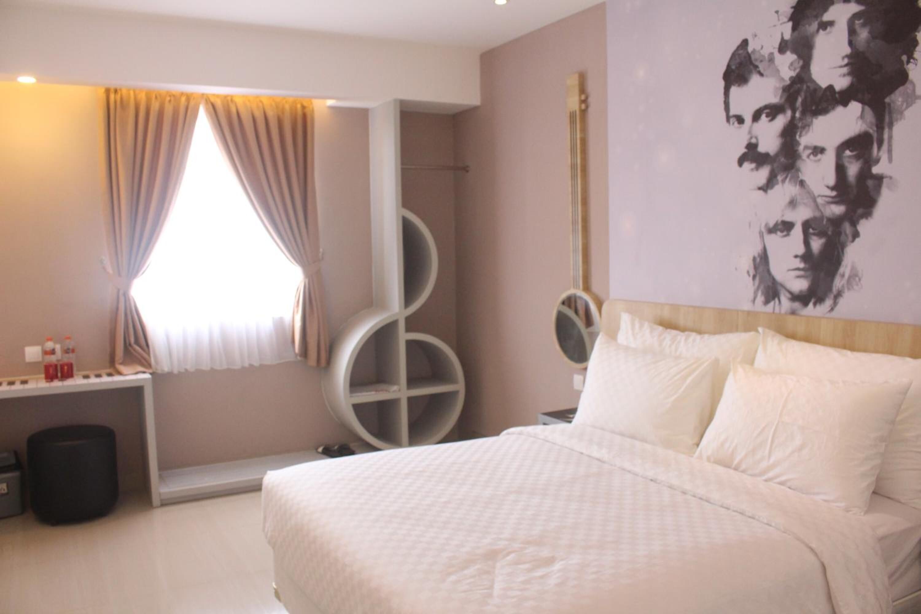 Une chambre d’hôtel avec un lit, un bureau et un grand miroir rond.