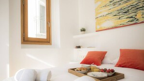 A hotel room with a bed, a breakfast tray, a window, and a painting on the wall. - Singular Stays El Balcon de Manet (Valencia / València)