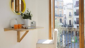 A balcony with a wooden chair, a small table with a radio, a mirror, and a potted plant. - Singular Stays El Balcon de Manet (Valencia / València)