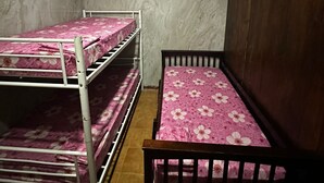 A room with bunk beds and a single bed, tiled floor, and an air conditioning unit. - Hostel the pod 33 (Panama City)