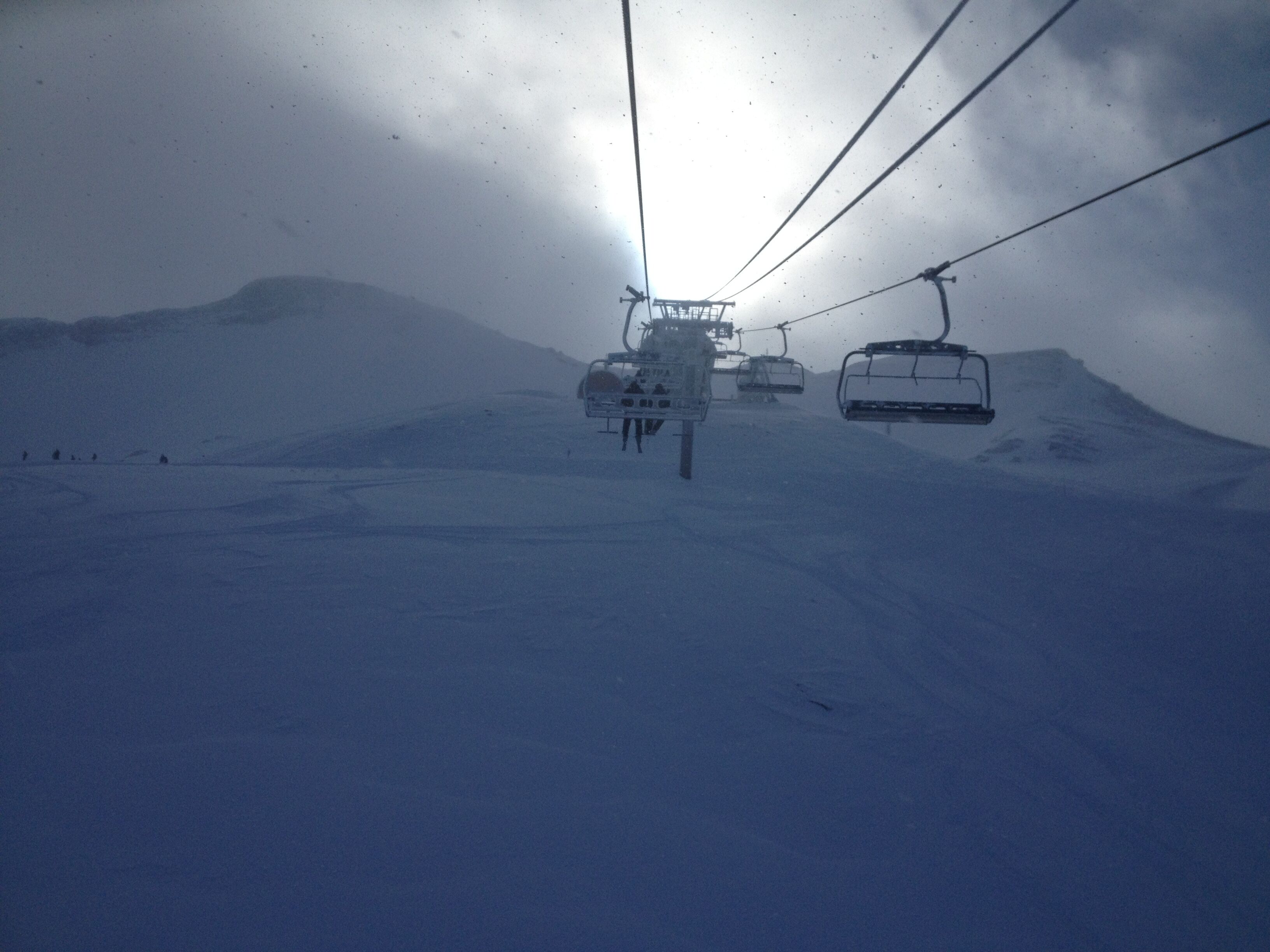 A ski lift in a snowy mountainous area.