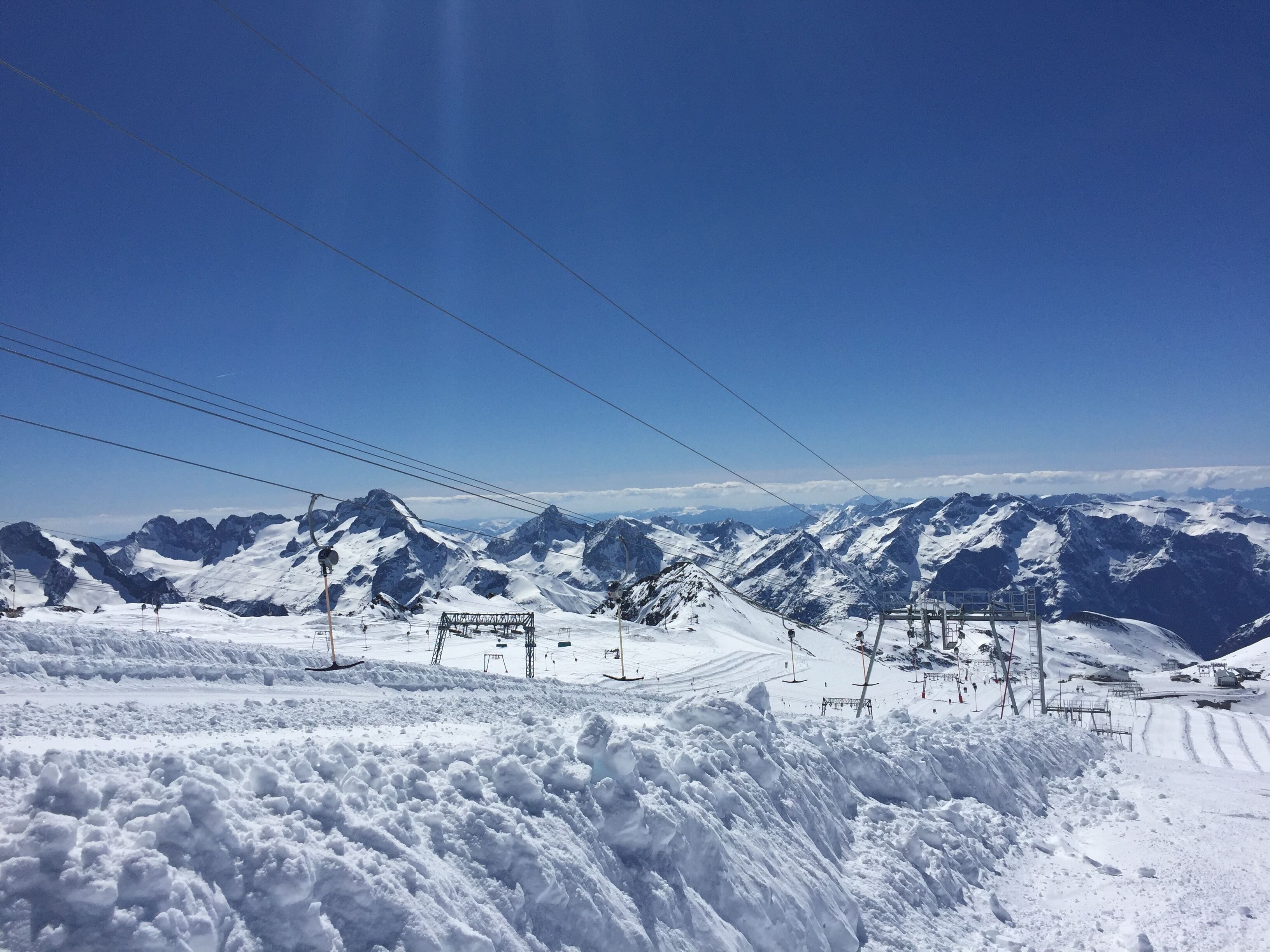 A snow-covered mountain landscape with ski lifts and a clear sky.