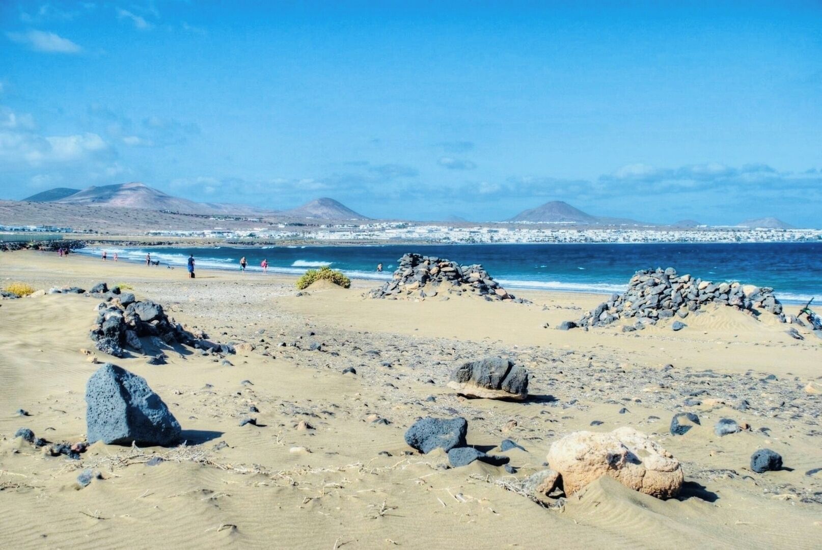 Una spiaggia con un terreno roccioso e montagne sullo sfondo.