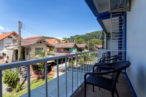 Un balcón con vistas a una zona residencial, con casas y vegetación.