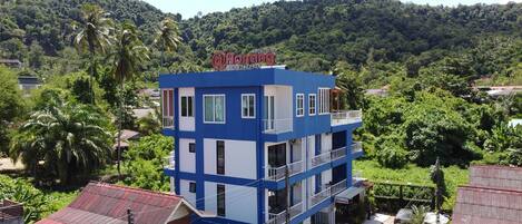 A two-story building with a blue and white facade, balconies, and a sign that reads "Aonang".