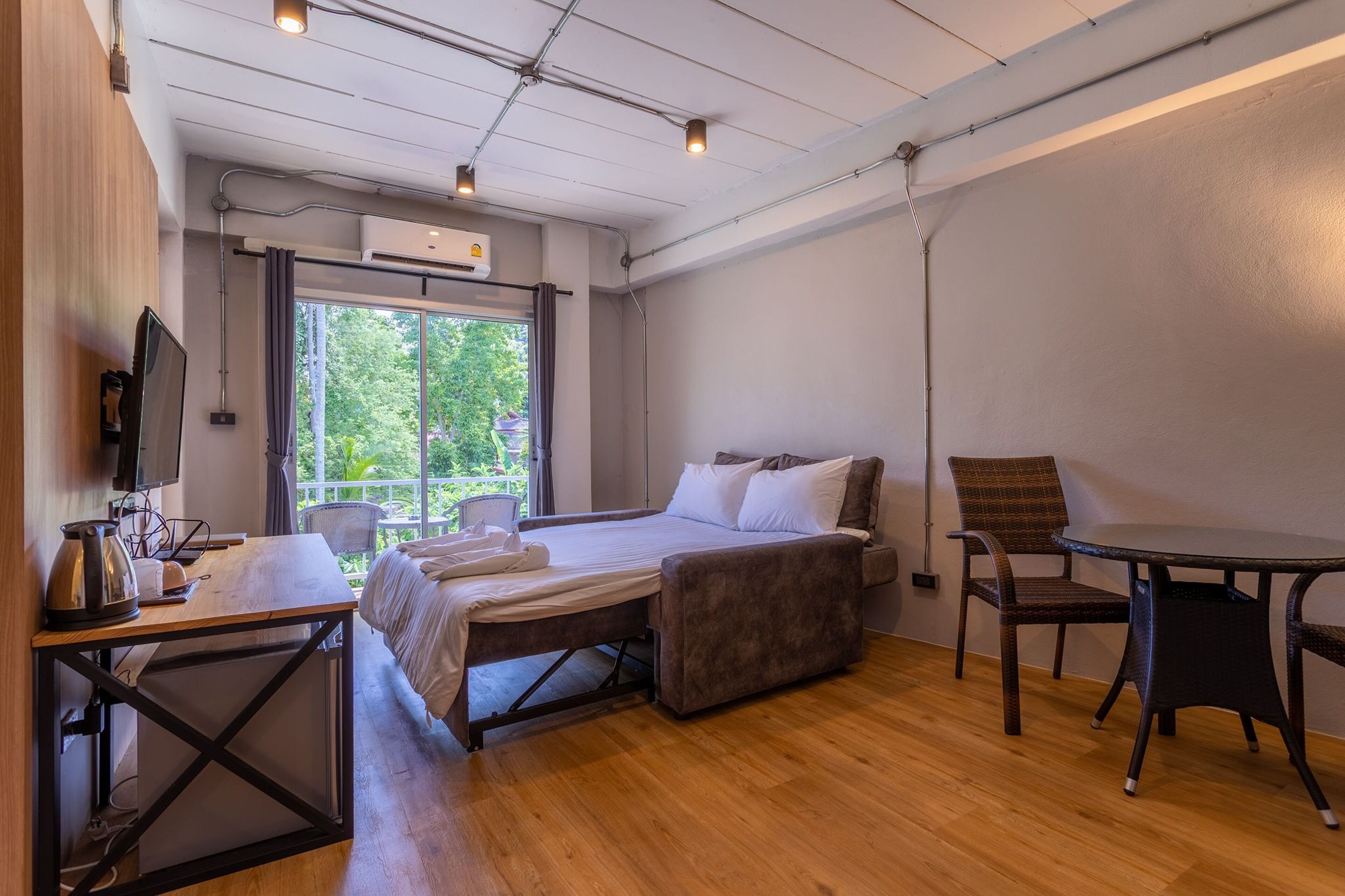 Una camera d'albergo moderna con un letto, una scrivania, una sedia e un tavolo.