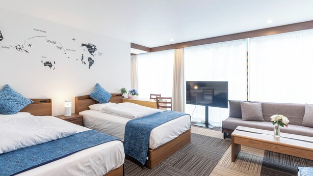 A hotel room with two beds, a sofa, a TV, and a large window. - Tabist Sakuragawa River Side Hotel (Osaka)