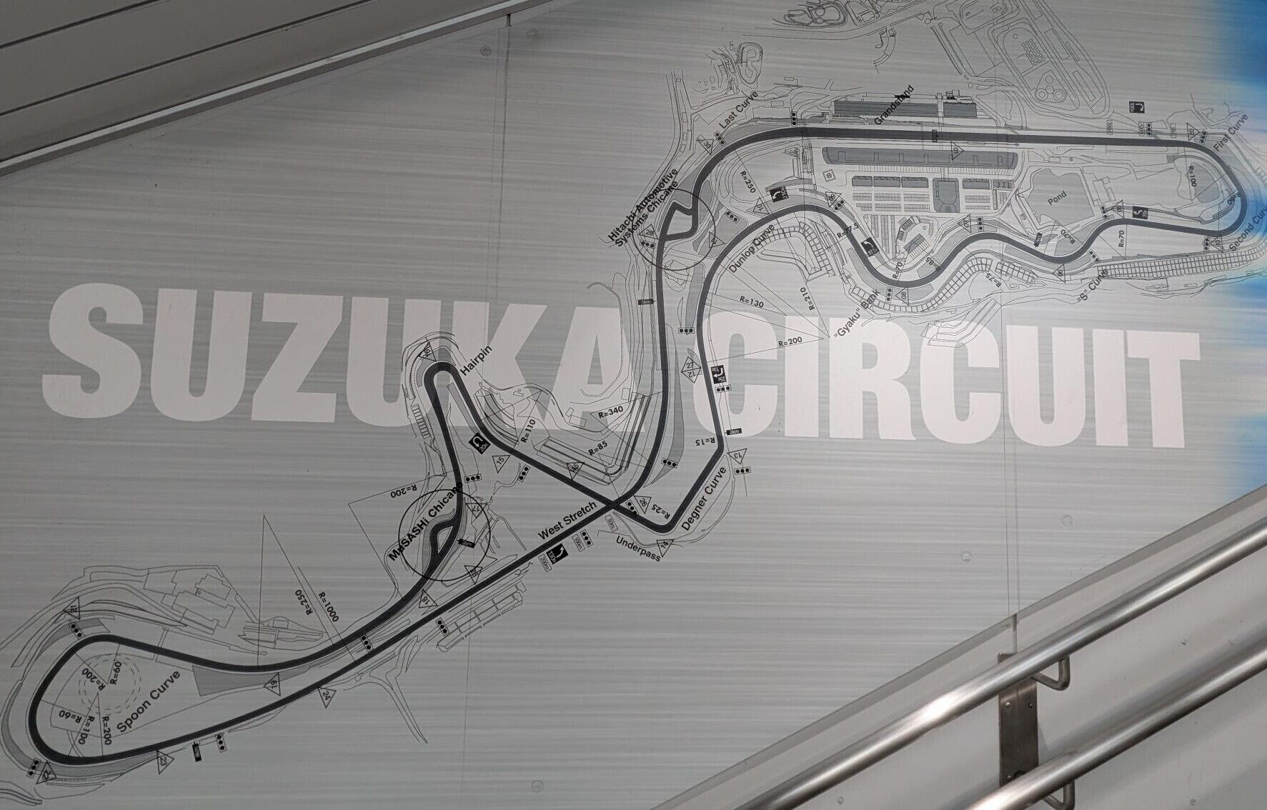 A detailed architectural blueprint of the Suzuka Circuit, highlighting its complex track layout and various sections like Hairpin, Degner Curve, and Mimasaki Chicanes.
