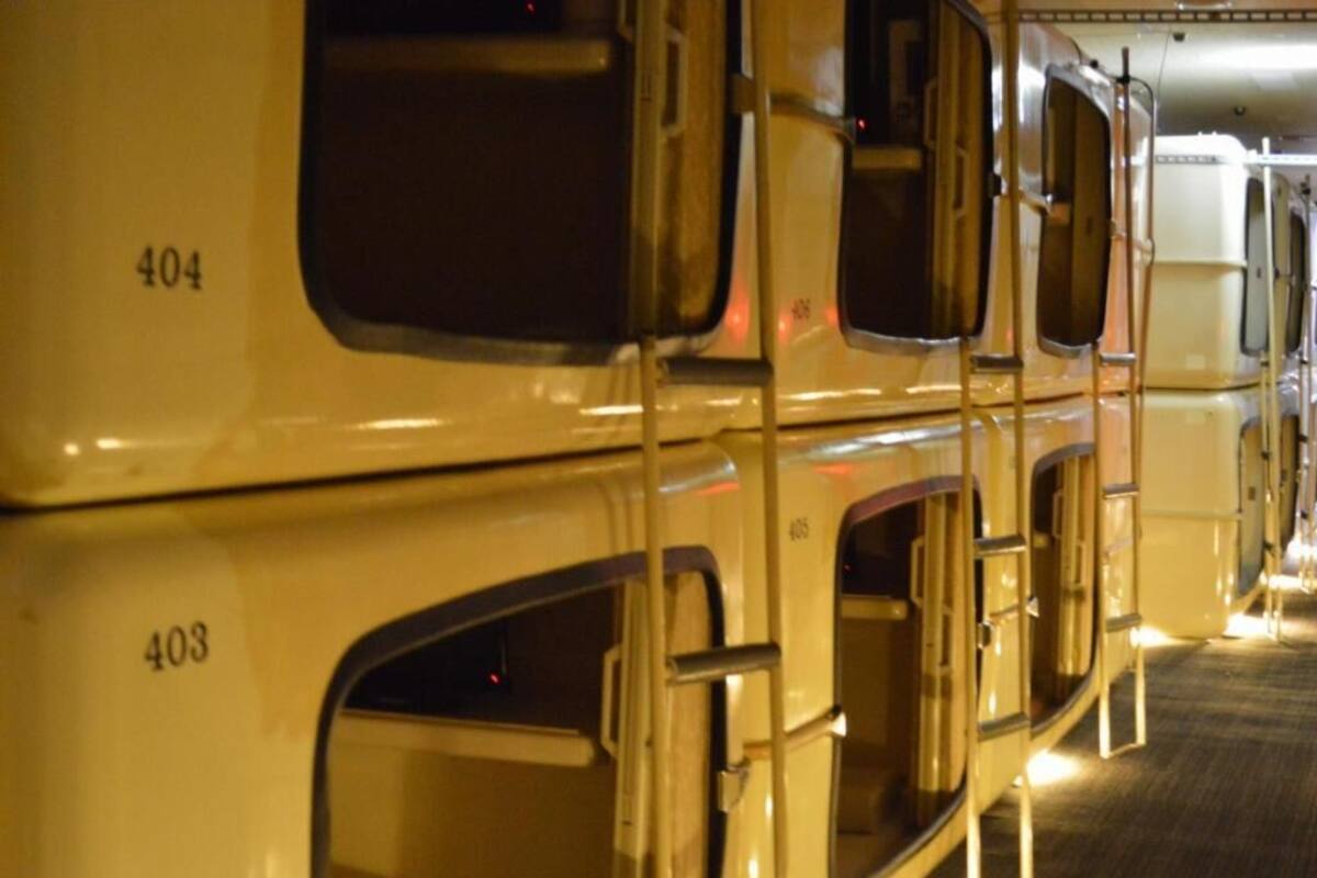 Interior de un vagón de tren con compartimentos numerados, pasamanos metálicos y suelo alfombrado.