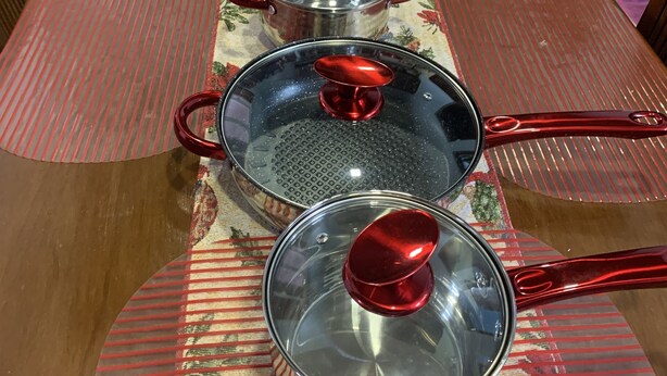 A dining table with six stainless steel pots and lids, arranged in a row. - Mactan Transient Townhouse (Lapu-Lapu)