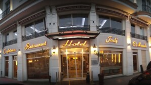 Un hôtel reconnaissable à son grand panneau « Jadj », avec un restaurant et un café situés au rez-de-chaussée.