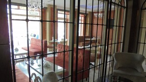 Une pièce avec une table en verre, des canapés rouges et un fauteuil blanc.