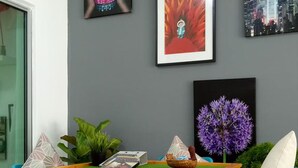 Un coin repas avec une table jaune, des chaises bleues et un tapis bleu à motifs.