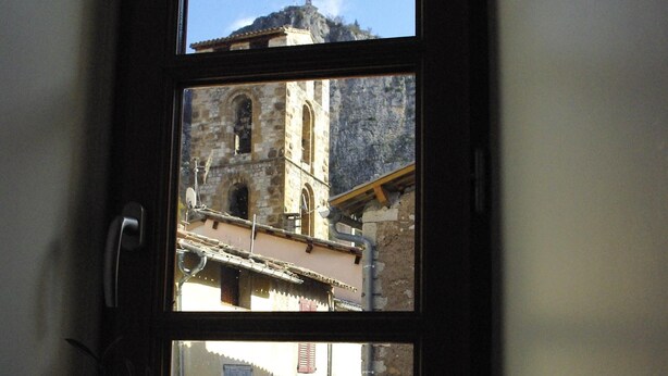 Una ventana con vistas a un edificio histórico con una torre de campanas.