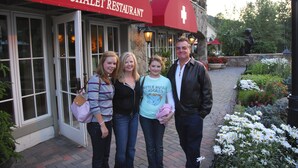 A group of people standing in front of a building with a red awning that reads "SWISS CHALET RESTAURANT". - Five Star Grand Lodge @ Peak 7:  Week of July 4th! (Breckenridge)