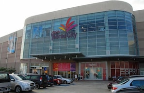 A modern building with a glass facade, featuring the 'FON' logo and 'Esprit' store signage.