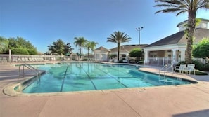 A swimming pool with a clear blue water, surrounded by a paved area with lounge chairs and palm trees. - Family friendly, 10 mins to Disney, WIFI, Resort style amenities, Backyard pool (Kissimmee)