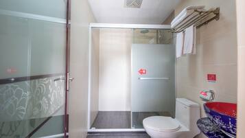 Une salle de bain dotée d’une douche à parois de verre, de toilettes et d’un lavabo avec un receveur décoratif.
