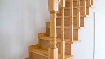 Un escalier en bois, doté d’une main courante et de plusieurs marches.