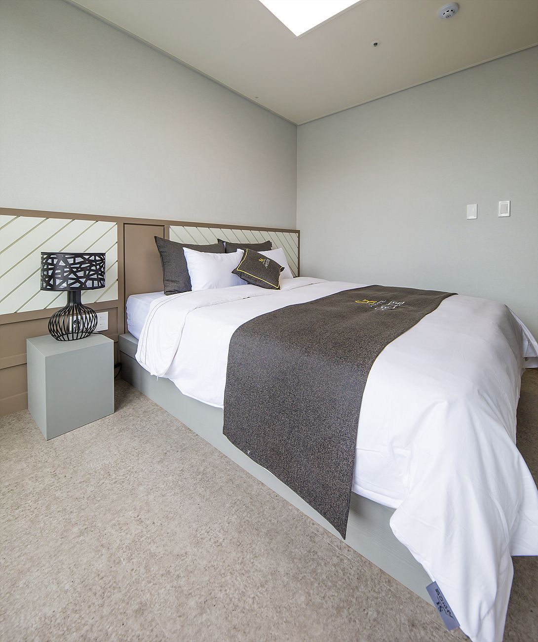 A neatly arranged bedroom with a bed, a bedside table, and a nightstand.
