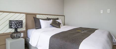 A neatly arranged bedroom with a bed, a bedside table, and a nightstand.