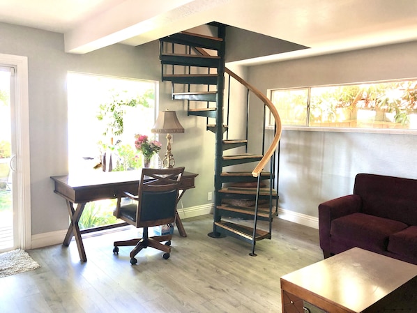 A modern interior with a spiral staircase, a desk with a lamp, a chair, and a sofa. - On an ISLAND bring your BOAT 24 FT Private Dock & PET FRENDLY! (Walnut Grove)