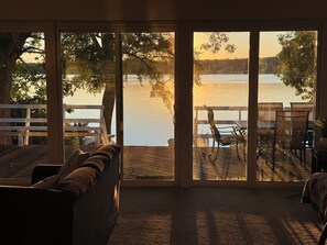 A room with a large sliding glass door leading to a deck overlooking a lake. - Cozy Lakefront Home - 278 FIVE STAR Reviews - Kayaks, Sunsets & Panoramic Views (Newburgh)