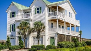 A two-story white house with green shutters, a balcony, and a covered porch. - Oceans 111 | Oceanfront with Elevator + Direct Beach Access! (Topsail Beach)