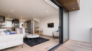Ein modernes Wohnzimmer mit einer Couch, einem runden Couchtisch und einem Essbereich mit einem Stuhl und Tisch.
