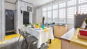 Una cocina moderna con comedor, ventanas amplias y zona de ducha visible.