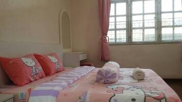 Cozy bedroom with a Hello Kitty themed bed, window, and bedside table.