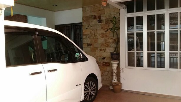 A white car parked in a covered area with stone walls and a large window. - Mama Mia Home - Bukit Mertajam (Bukit Mertajam)