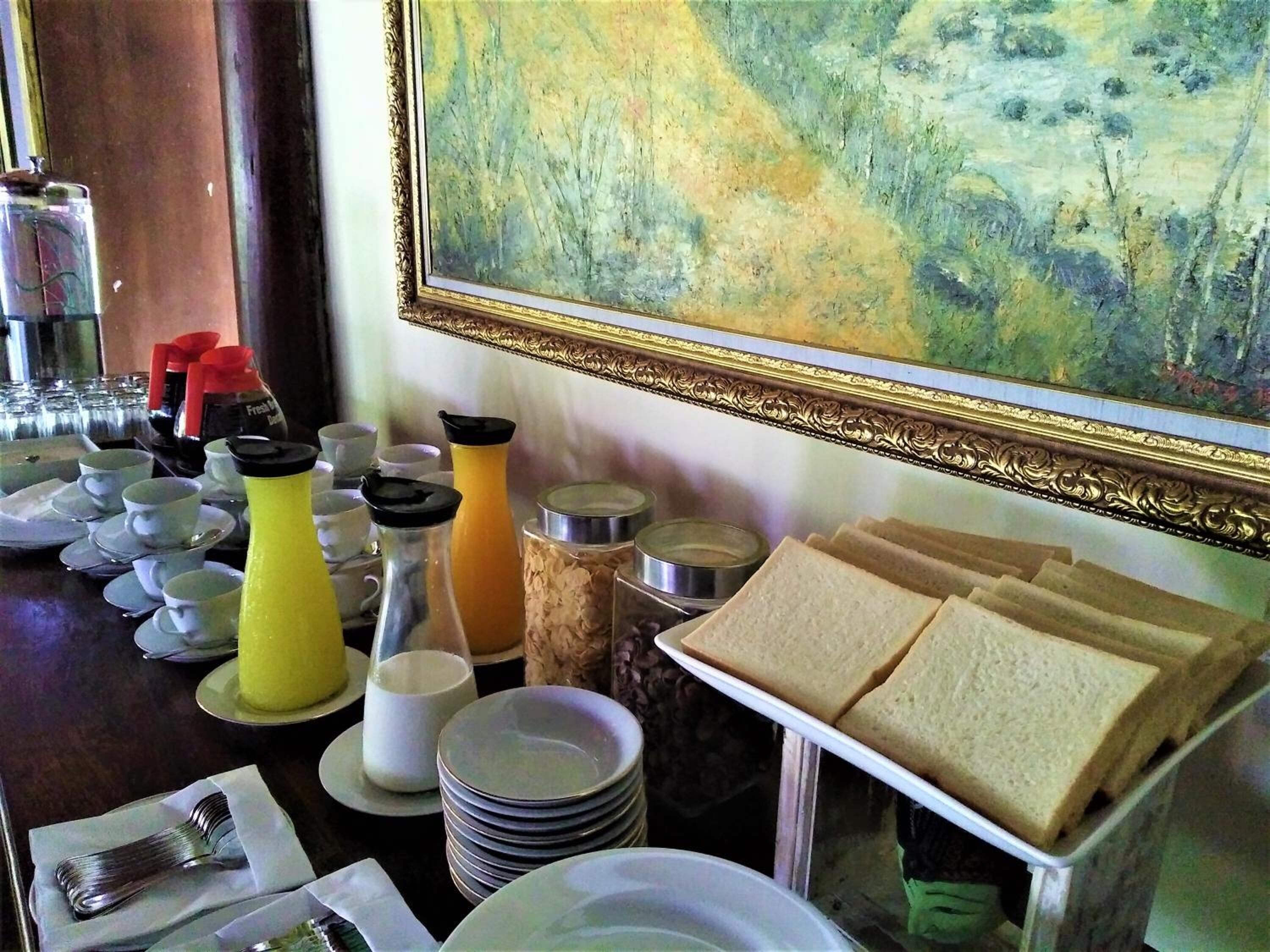 En frukostbuffé med ett varierat utbud av mat och serveringsredskap.